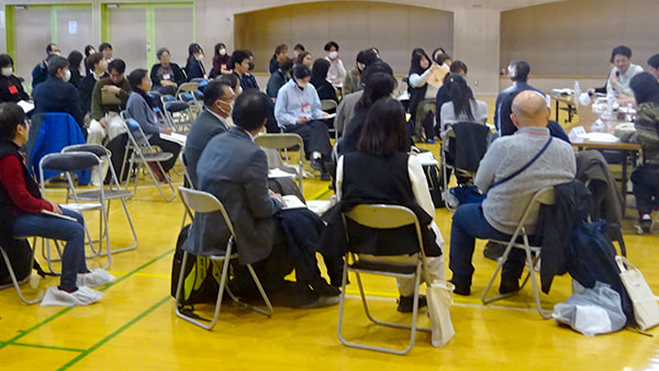 所属が異なる複数名で構成されたグループごとに分かれて椅子に座り、研究メンバーの話を聞いている様子