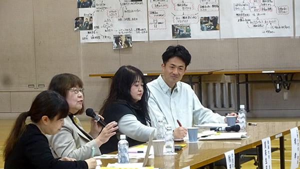 長机に座って話している秋田氏。隣に箕輪氏、蓬莱氏、堺氏。