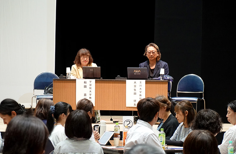 長机に座っている秋田氏・大豆生田氏と、その前で数名のグループごとに参加者が話し合っている