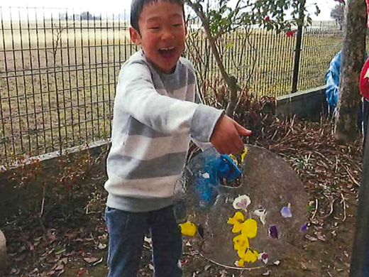 花びらが入った氷を持つ子どもの写真