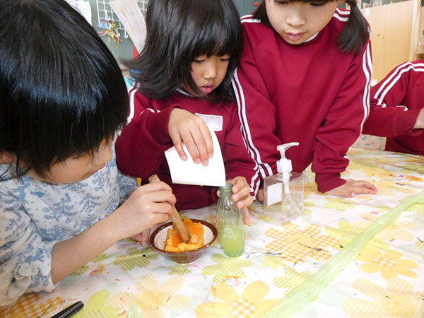 すり潰して色水を作っている子どもたちの様子