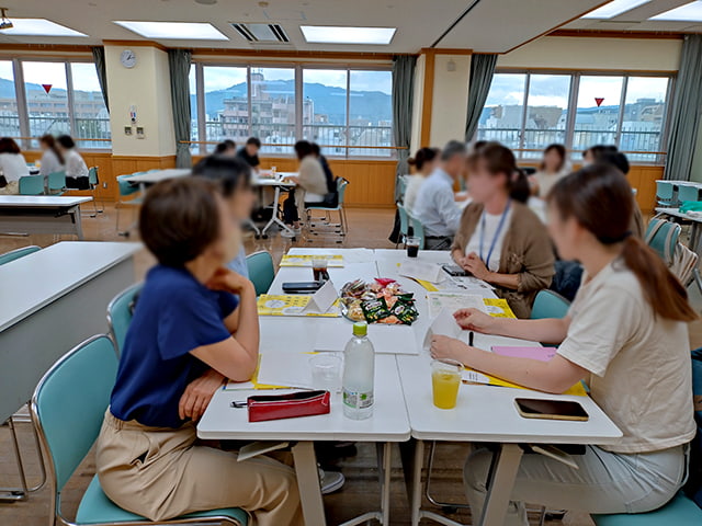 当日の様子（数名でテーブルを囲み話し合っている）